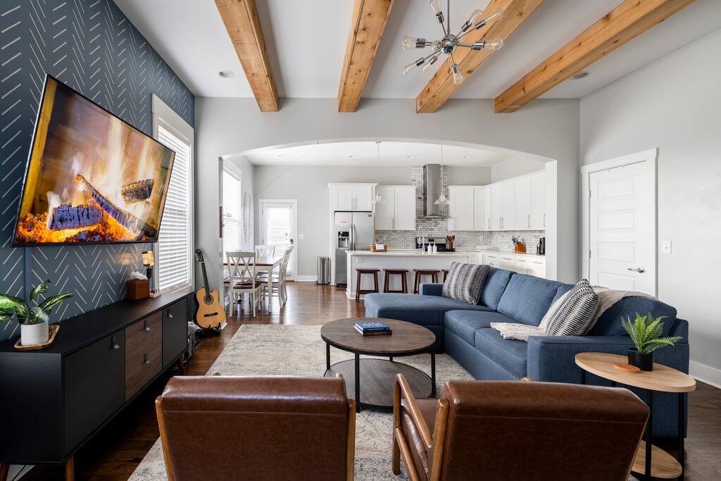Living room with exposed beam ceilings, 65" Smart TV, leather chairs and comfy couch is perfect for relaxing.