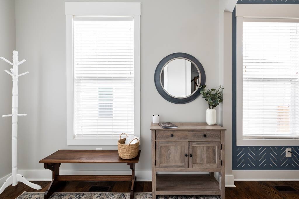 Entryway | Functional Decor | Welcoming Touch
Bright entryway with a wood bench, coat rack, round mirror, and accent cabinet—styled for convenience and charm as you settle into your Nashville stay.