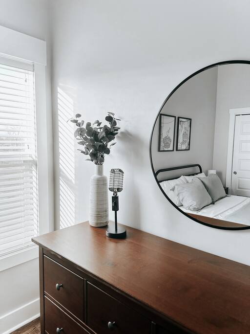 Bedroom | Dresser Area | Modern Decor
Minimalist dresser setup with a round mirror, vintage microphone-style lamp, and ceramic vase with greenery—styled for a clean, modern Nashville touch.