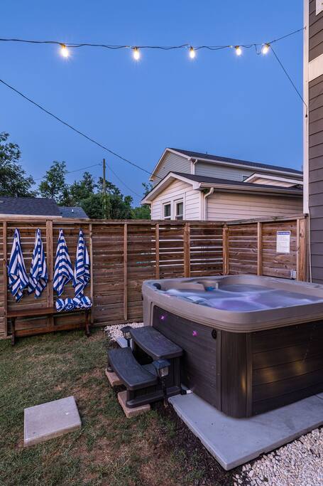 Backyard | Hot Tub Area | Private Retreat
Unwind in our private fenced backyard featuring a 7-person hot tub with LED lighting, towel hooks with striped robes, and a peaceful setting perfect for evening relaxation.