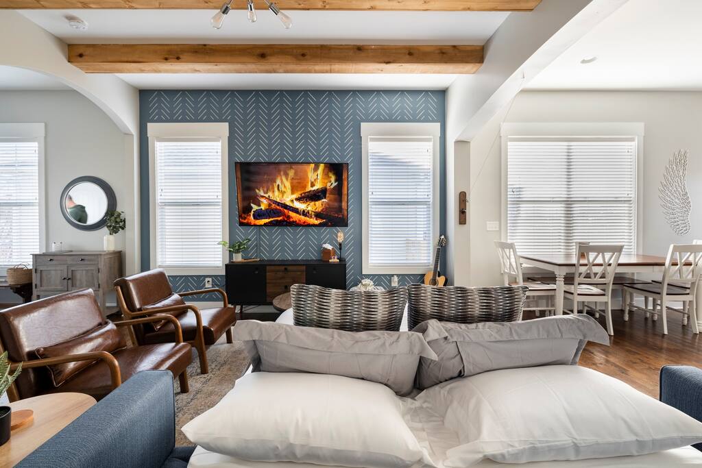 Living Room | Dining Area | 1st Floor
Open living space with a queen pull-out sofa, leather chairs, hand-painted accent wall with mounted TV, and dining area—perfect for relaxing or gathering with your group.