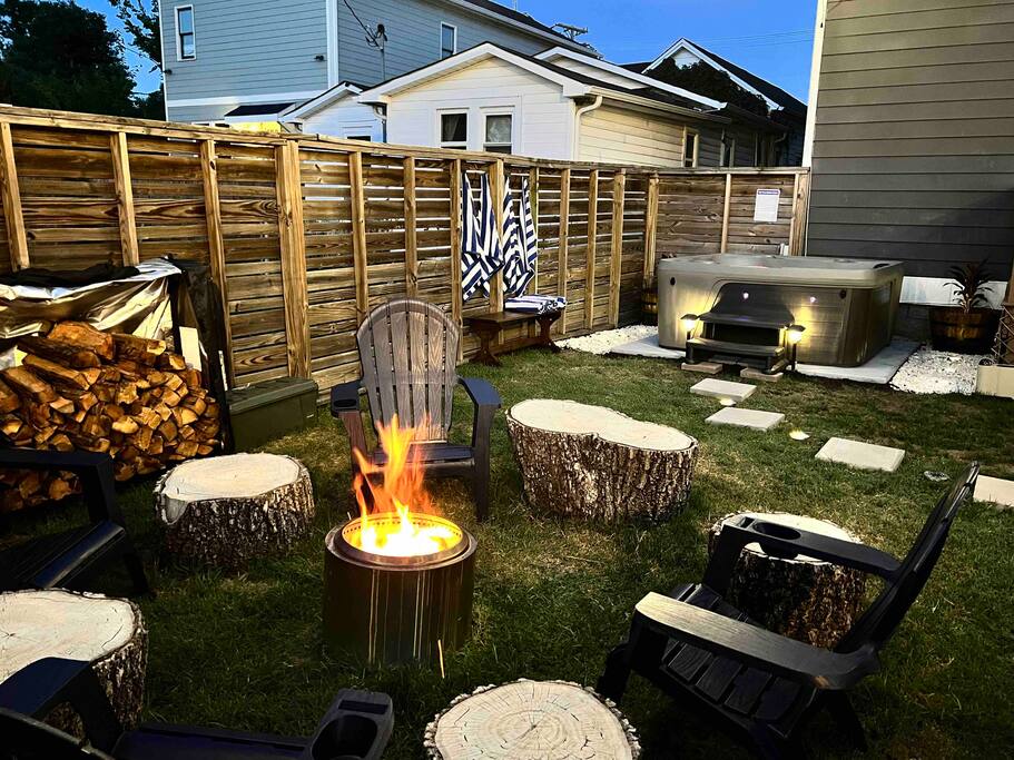 Private, fenced backyard with fire pit area equipped with a smokeless SoloStove bonfire, firewood, and stump seating. Plus a premium hot tub!
