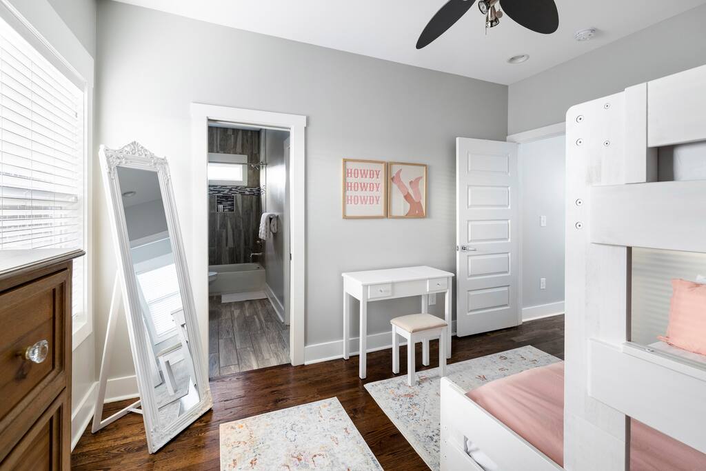 Bedroom | Bunk Room | Vanity & Decor
Bright bedroom featuring a twin-over-queen bunk bed, full-length mirror, small vanity desk, playful “Howdy” wall art, and soft rugs—perfect for getting ready or unwinding in style.