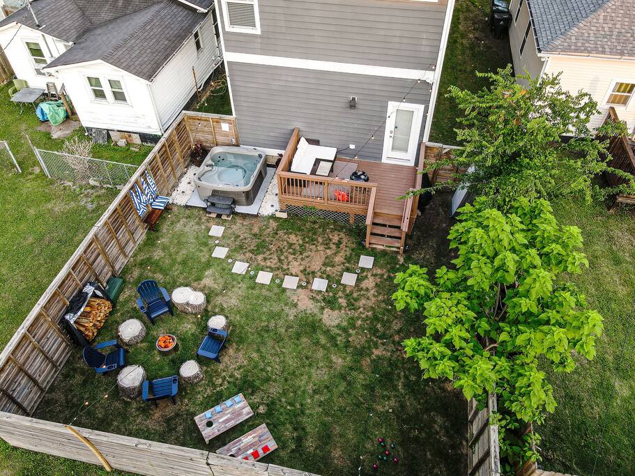 Aerial view of our private backyard. Hot tub, fire pit, corn hole, BBQ, and patio furniture.