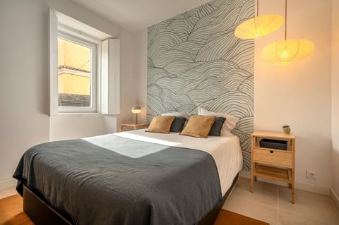 Chic Haven: Bright bedroom with a wave-pattern wall, plush pillows, and warm ambiance awaits you!