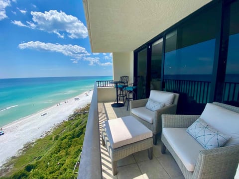 Balcony has two cushioned chairs with shared ottoman, two hightop dining seating, and a lounge chair (not pictured)