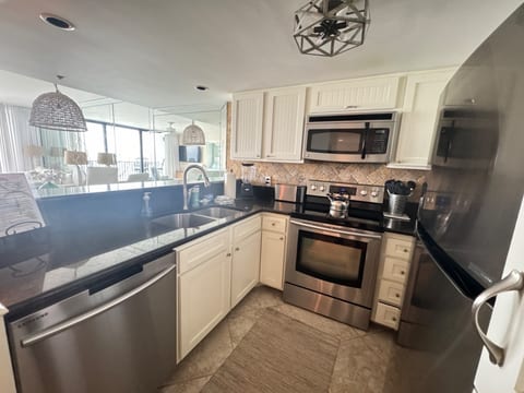 Kitchen overlooks dining and living room with views of the ocean