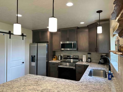 Kitchen with barn door pantry.  Additional appliances in the pantry. With fire extinguisher and first aid kit. Dishwasher is under the counter.