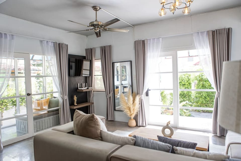 A cozy living room bathed in natural light, featuring sleek shelves, a modern TV for entertainment, and comfortable seating, all inviting relaxation.