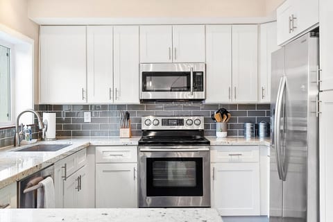The trendy gray and white kitchen is stocked with all the comforts of home!  Stainless steel appliances, dishwasher, fridge with icemaker/water dispenser, wine fridge, and a big pantry for your groceries. 