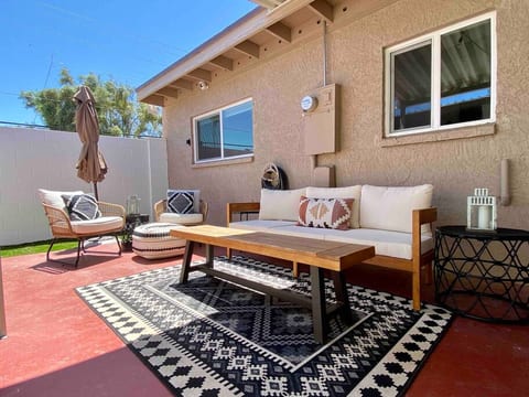 The large, private back patio features desert fauna, grassy areas for the pup, multiple seating areas,  and a teak outdoor table for dining al fresco!