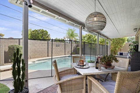 Private & fully fenced backyard features sparkling pool (not heated), grassy area for cornhole and bocce ball, sunloungers, covered patio with dining table for 4 and bar area, gas grill, wood firepit, and a lounge sofa for enjoying desert nights! 