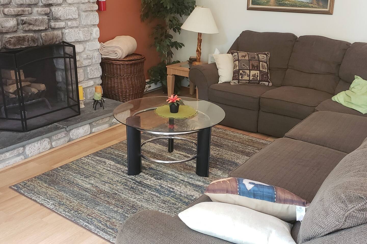 Cozy gathering spot around the fire. One section is a recliner and next to it a sofa bed. 