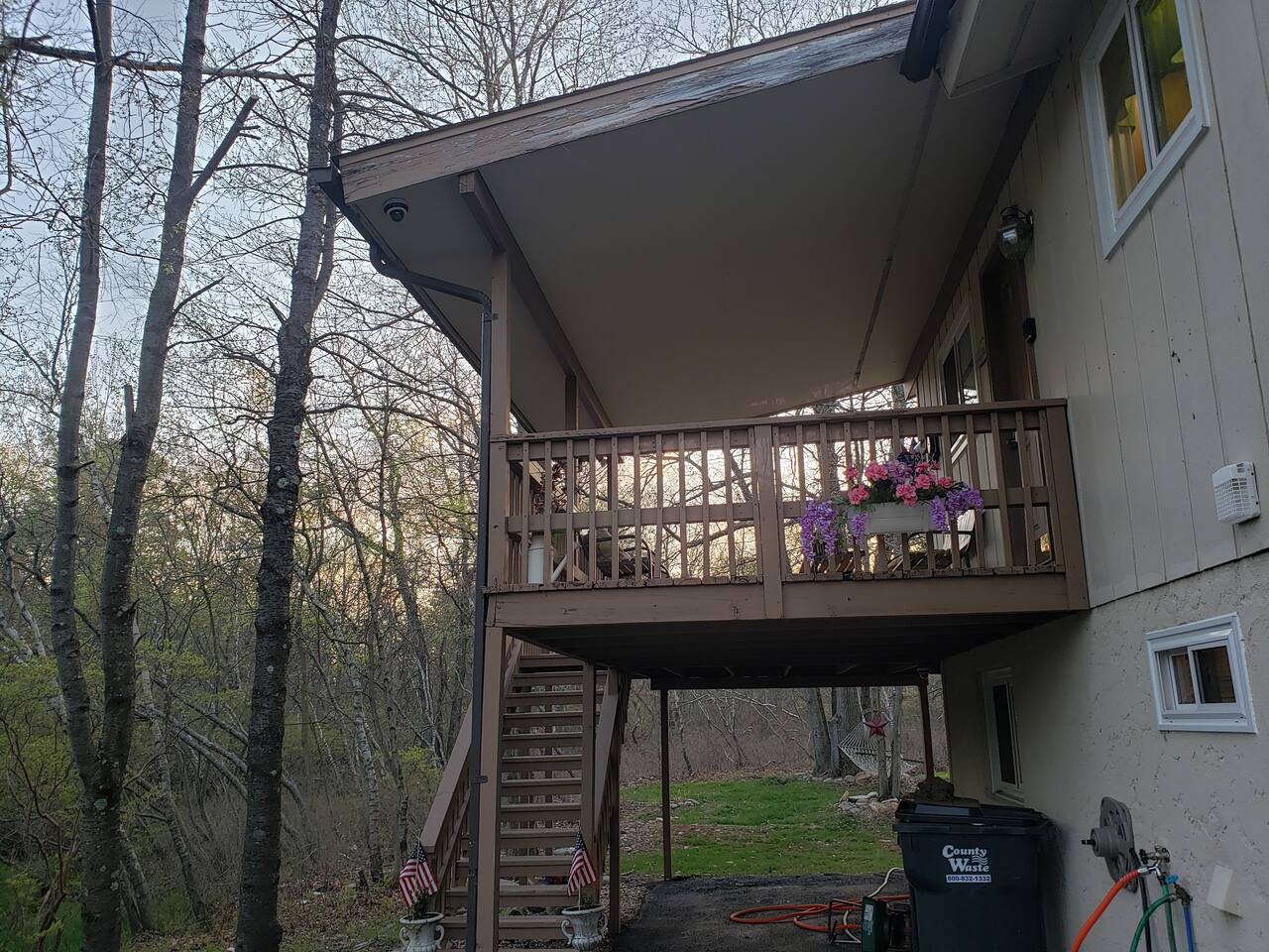 Grand entryway to the house is up the stairs to a covered deck overlooking the driveway. Straight back and to the right is the Den door. 