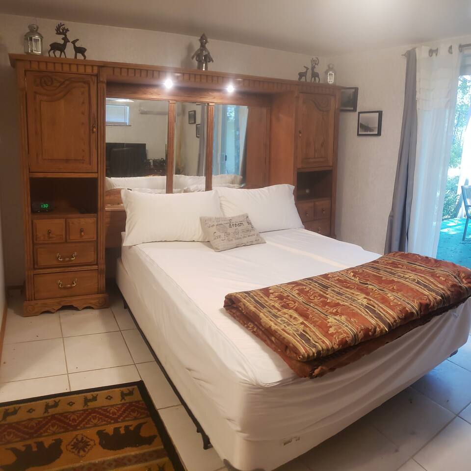 Master bedroom is larger space with queen bed, private bathroom, and access to the pergola. 