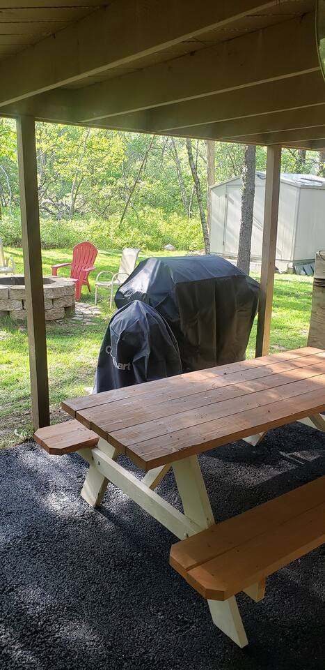 A picnic table to really give that outdoor woodsy camping feel while eating. Two grills available for your use. Small round charcoal one (charcoal provided), and a larger 5-burner gas grill with side burner. 