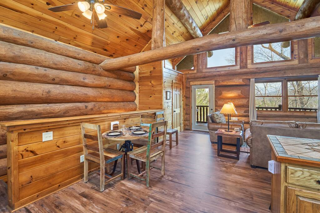 Dining space for four is provided on the main level. Behind the closed wooden door is a small guest bathroom. The other door leads out to the upper rear deck where a gas grill and dining table are found. - The Greenbrier Cabin - Gatlinburg, TN - Gatlinburg