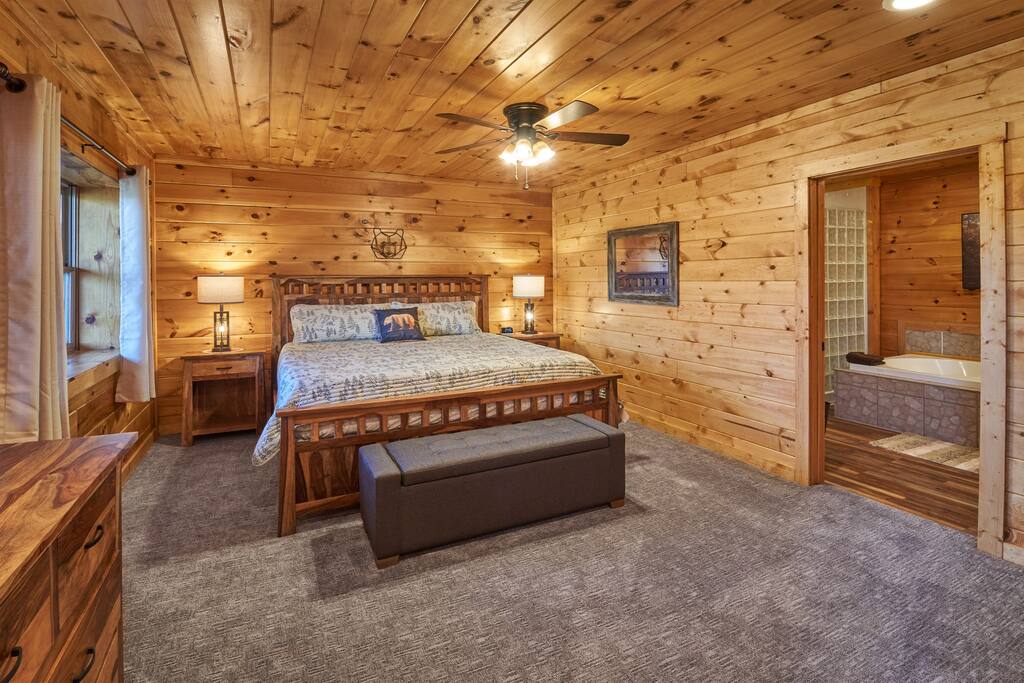 Bedding for the sleeper sofa is found in the trunk at the foot of the bed.  Behind where the camera is positioned for this shot is a nook for hanging clothes. Luggage racks are also provided. - The Greenbrier Cabin - Gatlinburg, TN - Gatlinburg