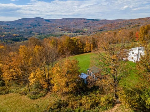 A look from above.  The blue cabin at the bottom is where you will stay. 

The bigger white house on the right is where owners live.  The buildings are separated by 150 feet.