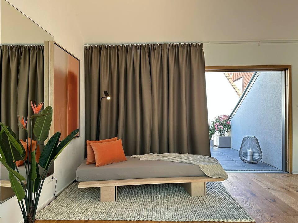 Wohnzimmer | Daybed vor der großzügigen Dachterasse mit Blick auf den Perlachturm am Rathausplatz
