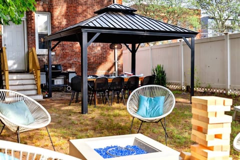 Beautiful Gazebo tent with a 10 seater outdoor dining table set, Coca-Cola cooler, Grill and a sitting area around a fire-pit