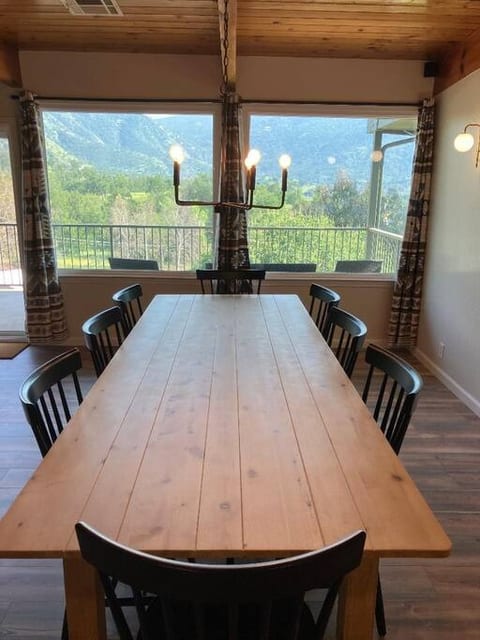 Enjoy meals with a view at this dining table, set against breathtaking hillside scenery. Large windows frame the stunning landscape, creating a serene and picturesque backdrop for breakfast, lunch, and dinner.