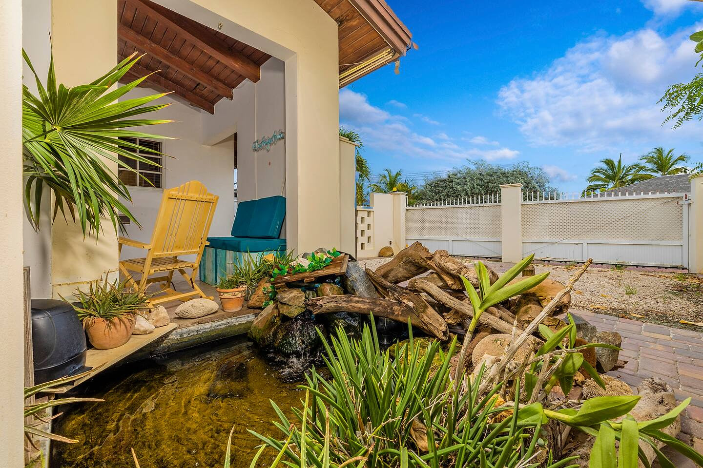 Relax by the koi pond with a waterfall feature in this peaceful corner of the outdoor living area. CasAmigos Walk 2 Eagle Beach, Bars, Food, Casino!