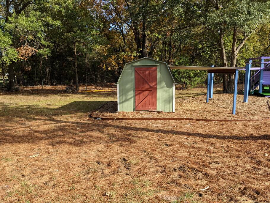 Kid's playhouse which includes a desk, chalkboard and chairs.