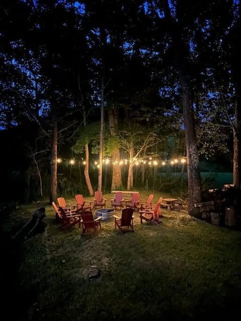 Wood-burning fire pit at night all lit up. Chairs for 14 people.