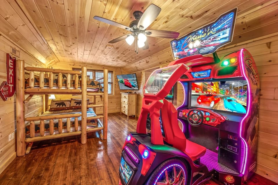 Game room with queen over queen custom log frame bunkbed with HD TV and full size racing arcade game in this wonderful cabin. Game units and board games available too!