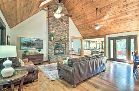Living room features large fireplace, comfortable sofas and vaulted ceiling