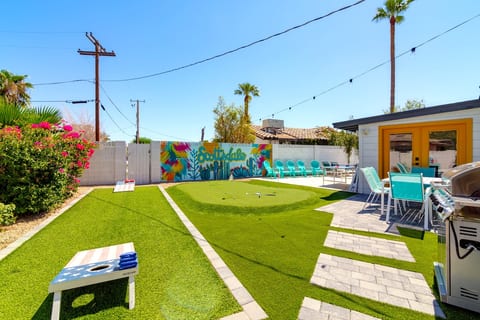 Backyard with fun games, putting green, and seating / dining areas on one side, and the pool with loungers on the other
