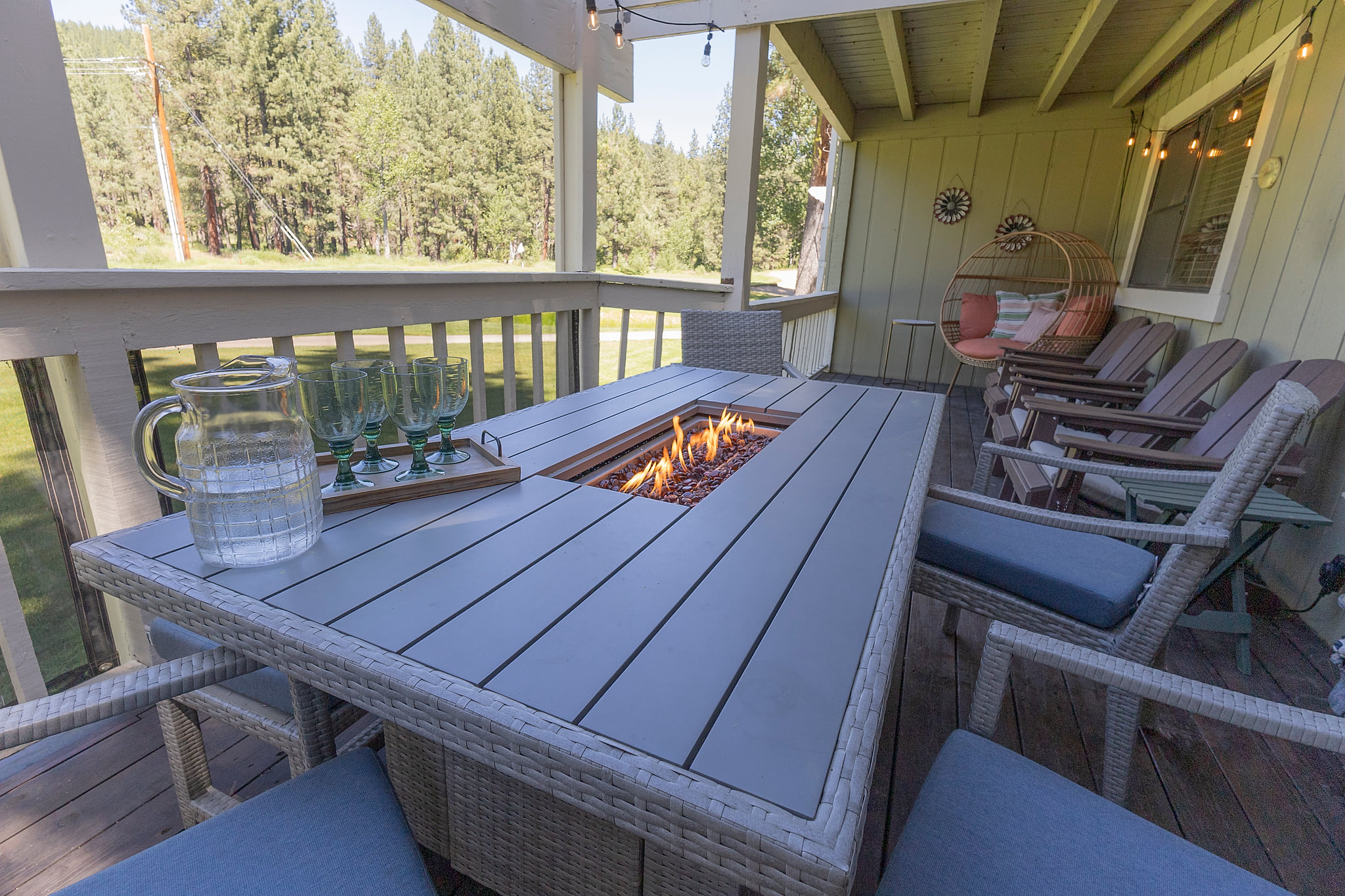 Private deck with fire table, cozy seating, and serene forest, river and golf course views
