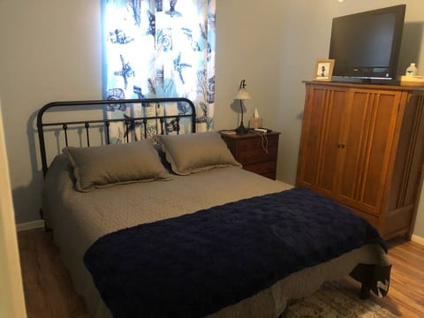 Queen bed, night stand with usb plug, and lamp. 32”TV with streaming device sits on top of Armoire with plenty of storage. Bedroom does have closet with hangers.