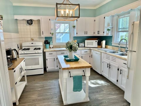 Kitchen with dual drip/keurig coffee maker, gas stove, microwave, dishwasher, refrigerator.