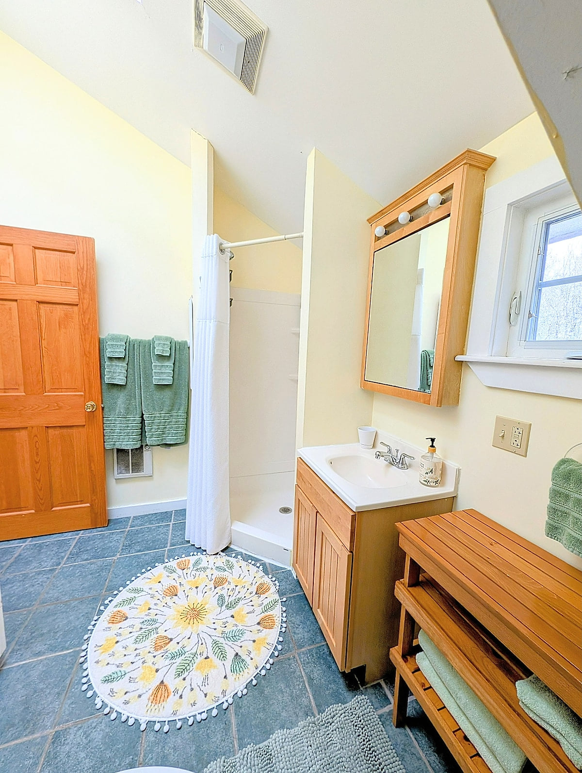 Bright full bathroom with walk-in shower, fresh towels, and plenty of space to get ready.