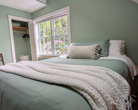 Queen bedroom with a plush new mattress topper and soft, cozy bedding.
