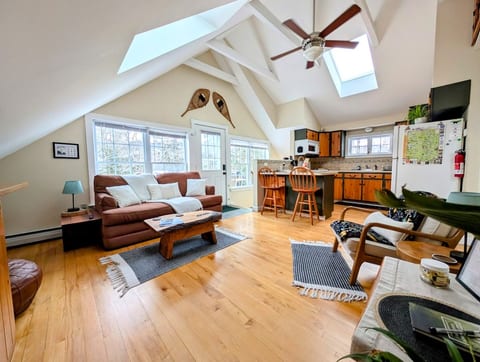 Open living room and kitchen area. 40' smart TV, full size pull out sofa bed, 2 bar stools at kitchen counter for dining.
Door leads to 2nd story deck & stairs (summer entrance).
Interior stairs are the winter entrance through garage.