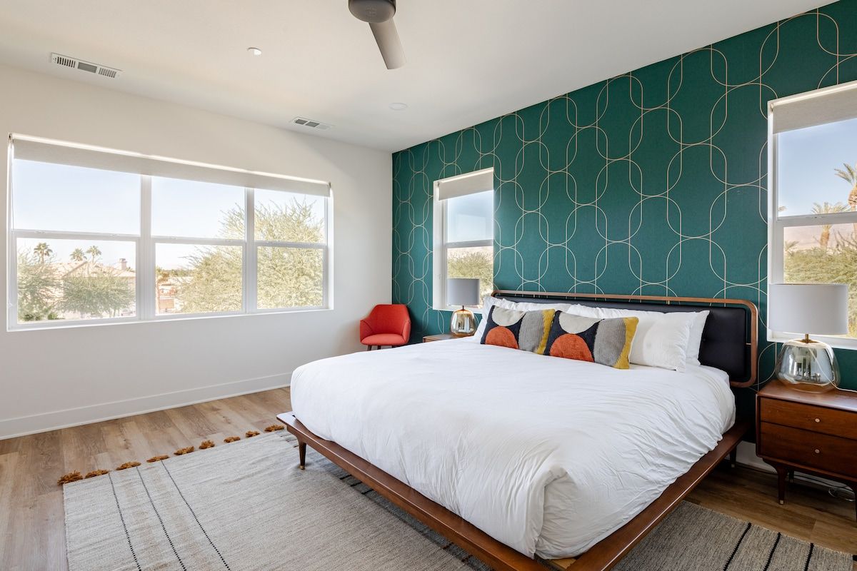 Welcome to the primary bedroom, featuring a spacious layout and a plush California king bed for ultimate comfort. Enjoy entertainment on the 65" smart TV or step onto the private balcony to soak in breathtaking views of the desert and lake.
