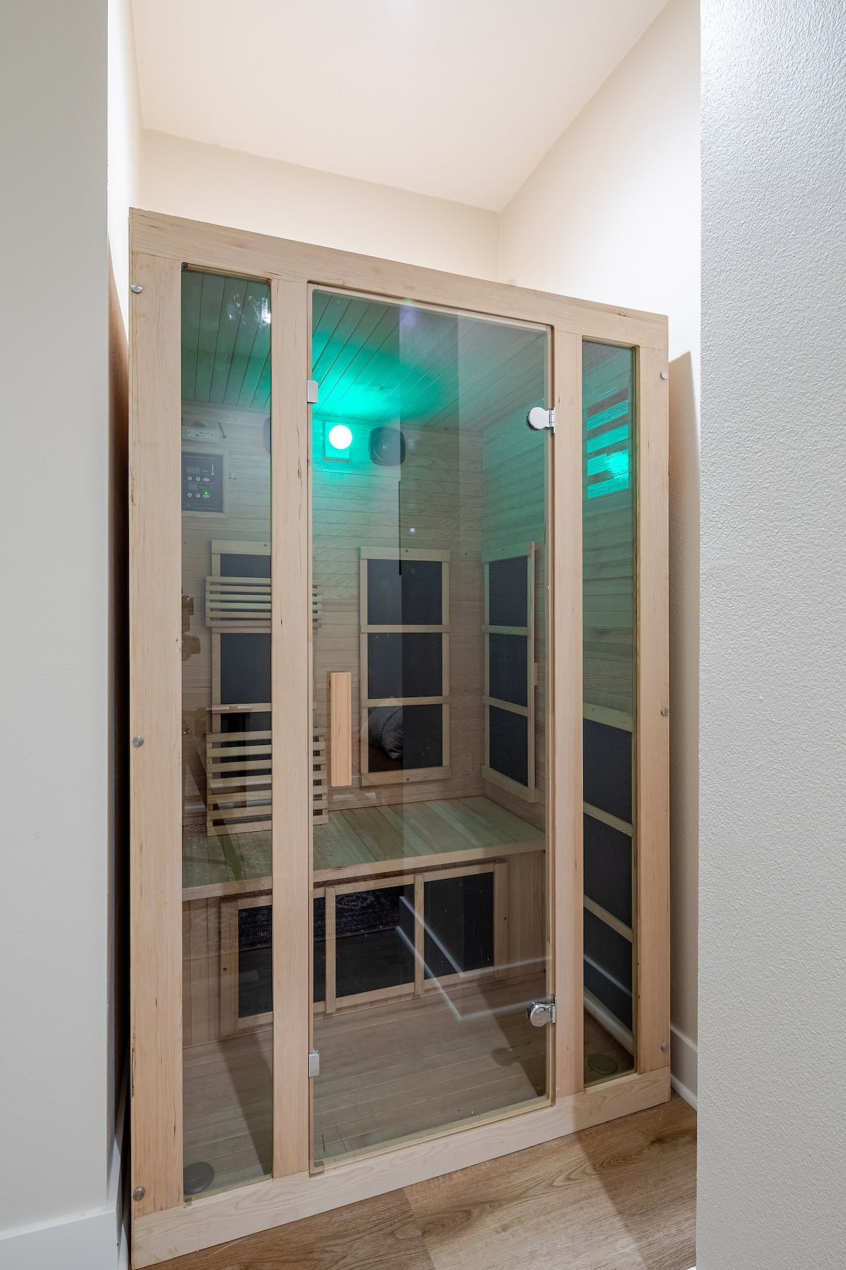 Warm, inviting wooden sauna interior with soft, ambient lighting and multiple chromotherapy light options to customize your mood. Connect your music via Bluetooth and unwind in this perfect cozy retreat