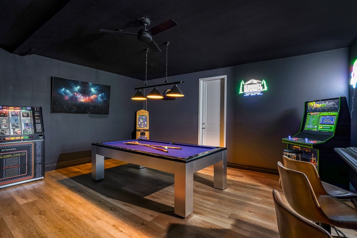 A fun game room for friends and family includes a pool table, 75" Smart TV, bar, multi-arcade, professional Shuffleboard and pool table, Jukebox, and more.