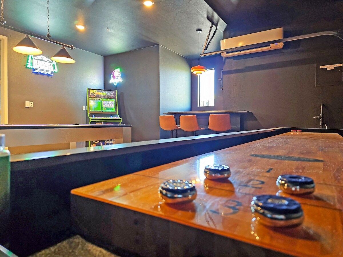 Endless entertainment awaits in this game room, complete with shuffleboard and your own private bar.