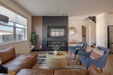 The living room features a cozy fireplace, built-in TV, and a very comfortable sofa, perfect for enjoying a movie, game night, or quality time together in a warm and inviting setting