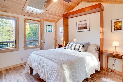 Bedroom 3 - the sunroom. Surrounded by windows with a door leading to the covered porch w/ swing and a bistro table. Perfect for catching sunrise! A second door leads to a private woodland garden.