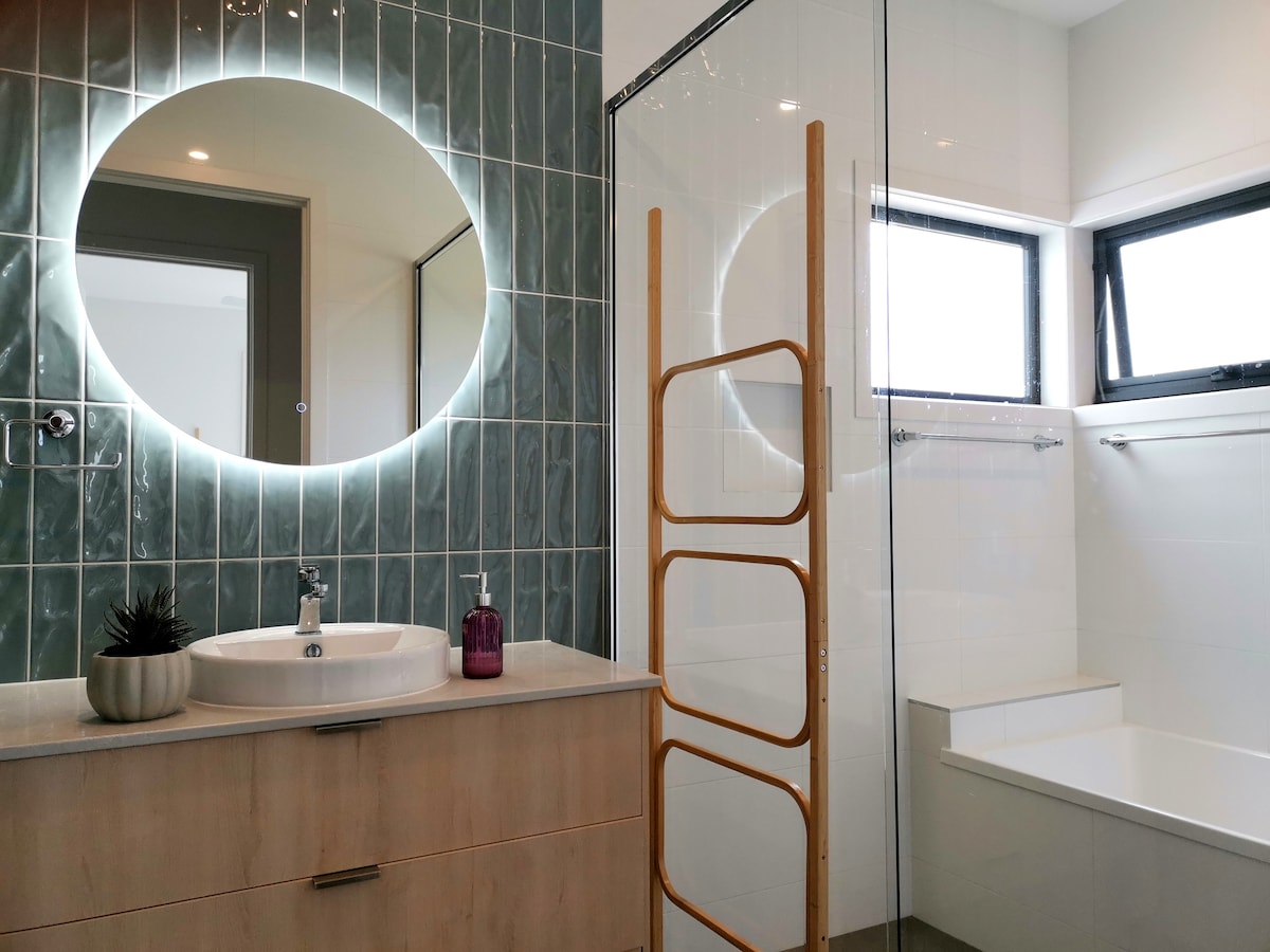 Main bathroom with basin, shower, and bath. A separate toilet is next door.