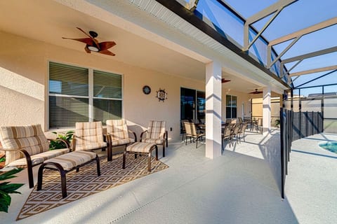 Large full-width lanai (patio) with ample seating for dining and relaxing, complete with outdoor corner shower for guests enjoying the pool and spa.
