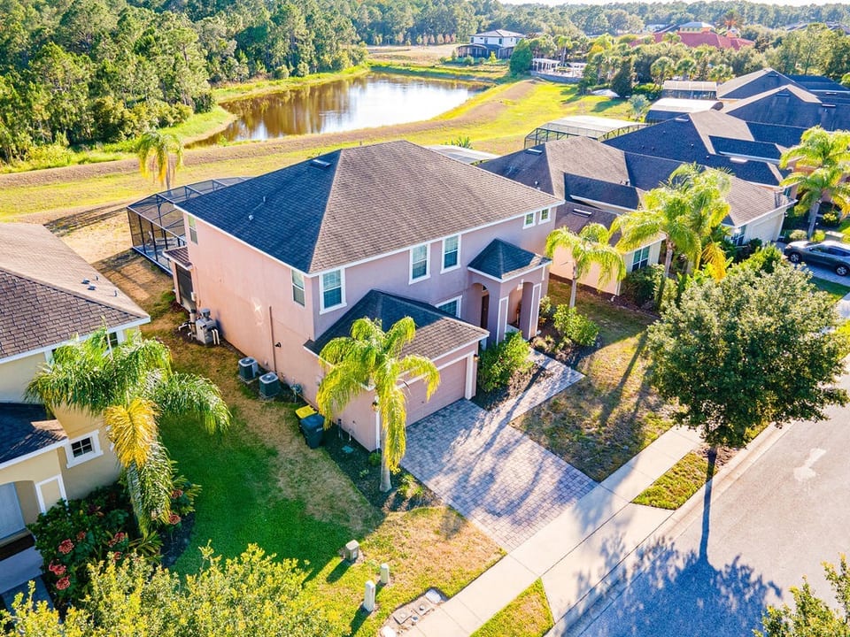 Aerial view of Sunset Palm Villa surrounded by conservation woodland and lake.