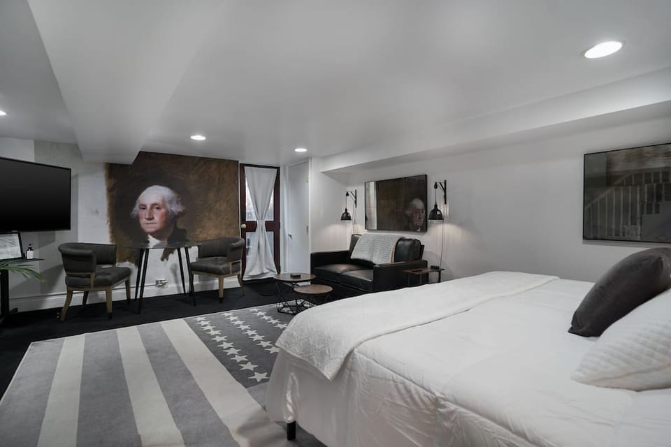 View of main area containing a King Size bed, sitting area, dining room table, TV, and Georgie, of course!