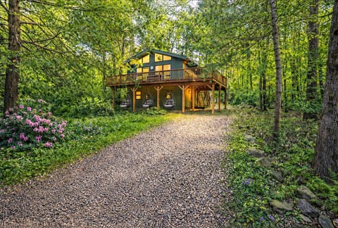 Tucked beneath a serene woodland canopy, this cozy cabin retreat invites you to unwind in style. Enjoy peaceful mornings or twilight evenings swaying in your private hanging chairs under the deck, surrounded by nature, quiet, and warm cabin charm.