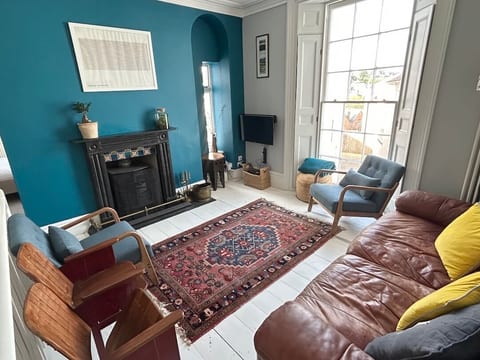 Cosy lounge with comfy sofa, Roku TV and wood burning stove